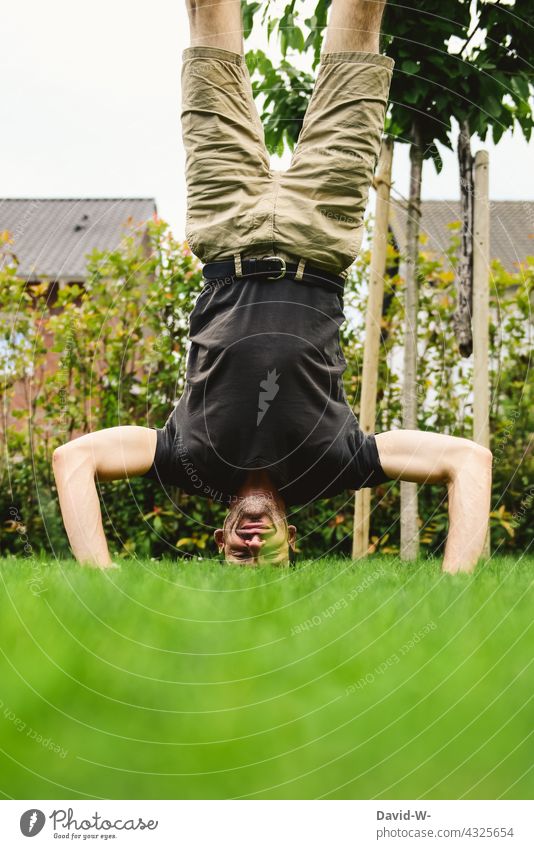 on the head - headstand on the meadow Go crazy Man Handstand Smiling Joy Ambitious Ease balance Balance discipline Body tension Body control Healthy Fitness