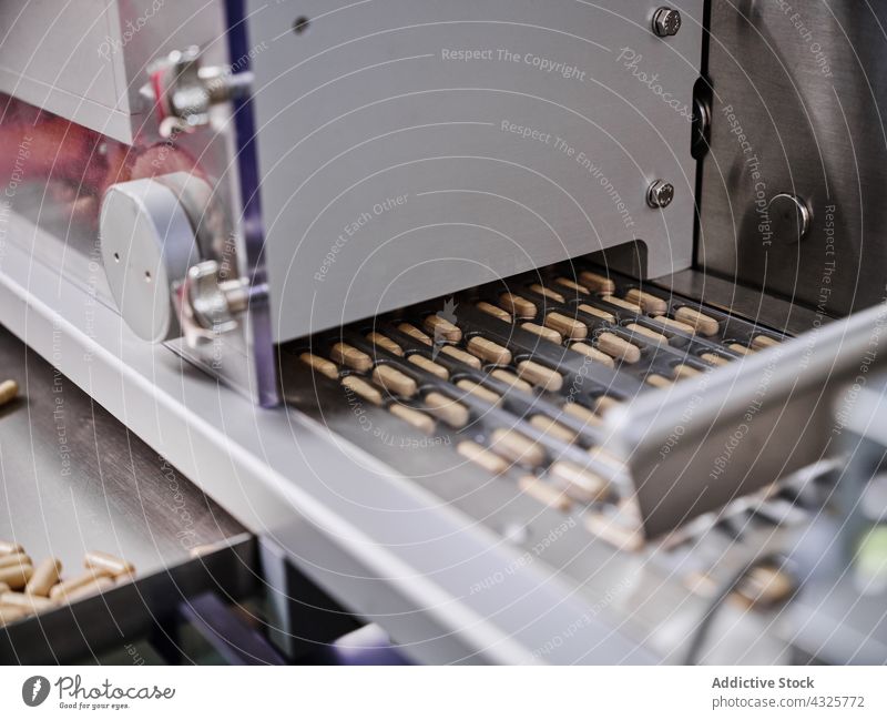 Pills on conveyor at pharmaceutical factory pill manufacture production machine laboratory blister machinery medicine equipment industry professional technology