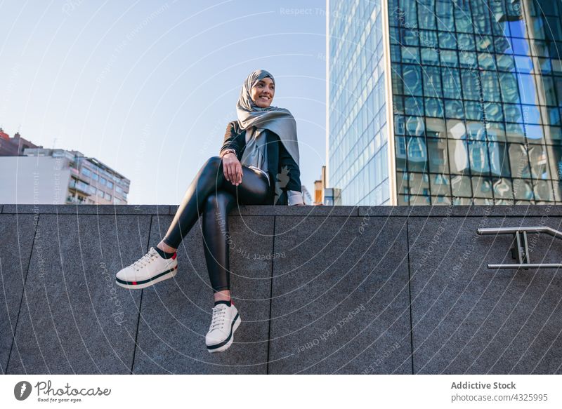 Stylish Muslim woman in hijab in city headscarf style trendy smile urban cheerful street female ethnic muslim young happy glad joy culture fashion tradition sit