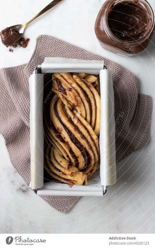 Babka dessert with chocolate topping in baking dish babka bakery uncooked kitchen raw dough cake paste table baking paper cuisine pastry ingredient delicious