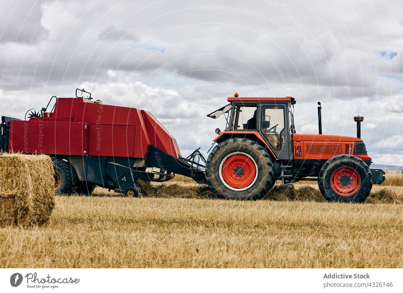 Tractor and haystack on field roll tractor dried agriculture rural summer countryside machine vehicle transport environment farm landscape modern season meadow
