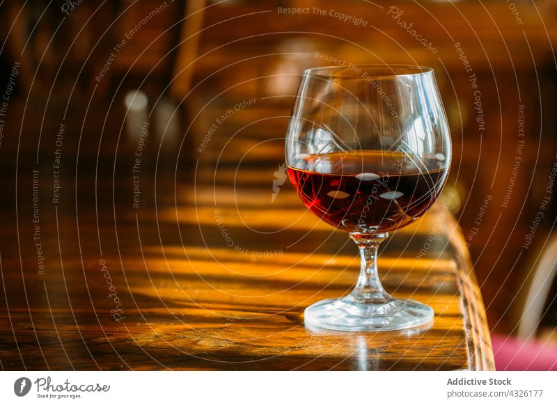 Cognac glass on wooden table with natural light alcohol background barman bartender beverage bokeh bourbon cocktail cognac drink food lights liquor mixologist