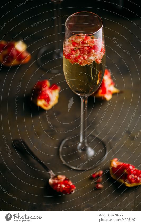 Champagne cocktail with pomegranate alcohol background bartender beverage bokeh bubbles champagne cold drink food fresh fruit garnish glass mixologist mixology