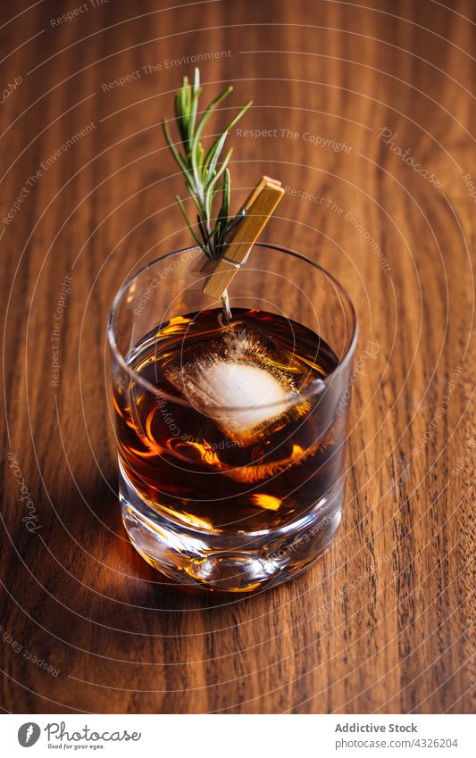 Glass of whiskey with rosemary alcohol background barman bartender beverage bokeh bourbon cocktail cognac drink food garnish glass ice lights liquor mixologist