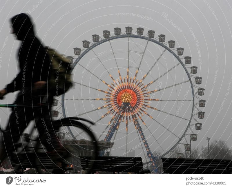 a winter day at the Ferris wheel comes to an end Silhouette Pedestrian Bicycle Human being Structures and shapes Theme-park rides Going Fairs & Carnivals