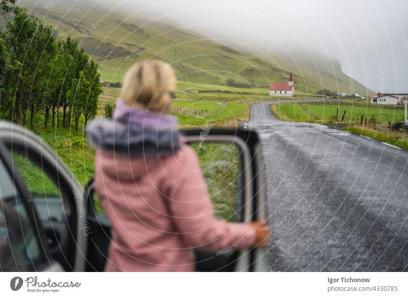 Woman enjoyed typical rural Icelandic Church with red roof from the rent car in Vik region. Iceland church horizontal woman icelandic landscape chapel europe