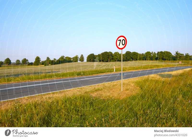 Speed limit sign by a countryside road. highway rural speed limit traffic sign landscape travel journey road trip safety Poland Europe 70 empty sunny horizon