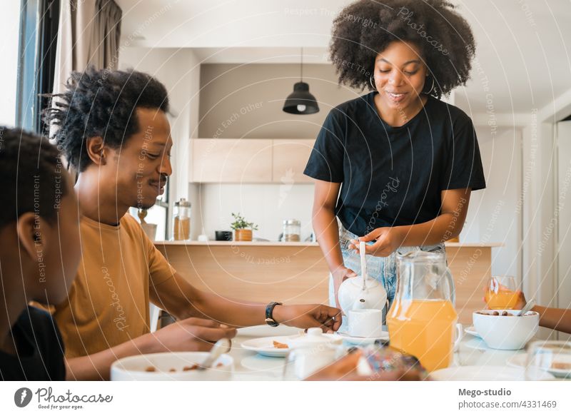 Family having breakfast together at home. morning family child cute healthy food serving mixed-race african american person domestic casual life leisure