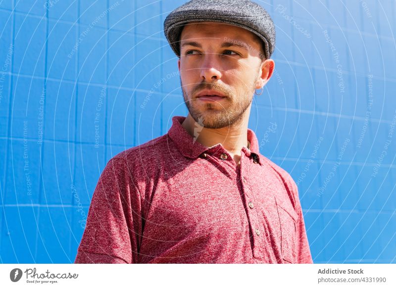 Man in trendy outfit on street man summer joy sunlight style carefree enjoy male freedom young beard polo modern lifestyle shirt cap free time headwear look guy