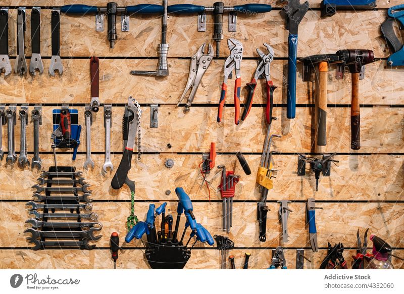 Assorted tools hanging on wall in workshop repair service instrument assorted various garage metal equipment set collection toolkit steel shabby object detail