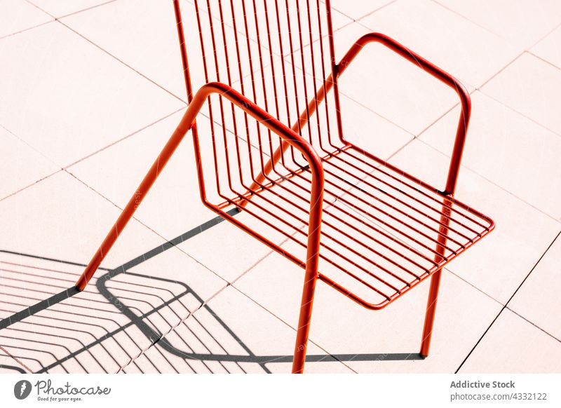 Metal chair with shadow in sunlight red metal summer furniture modern grid grate stripe color design minimal simple geometry shape style object material outside