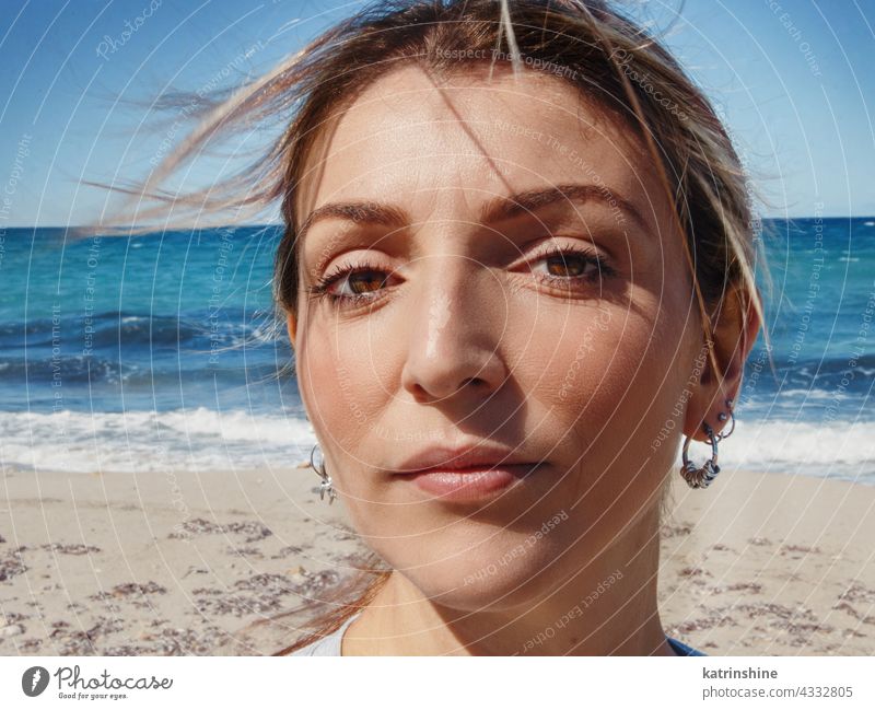 Young woman head close up Woman Close up Thoughtful Sea Beach Windy Alone Headshot face sky waves 20s 30s Lady young adult Portrait Blue Serious Lonely