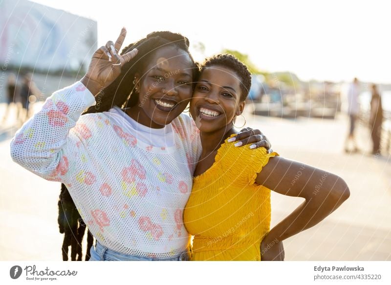 Portrait of two beautiful women standing together outdoors diversity millennials friends friendship sisterhood black live matter afro proud real people candid
