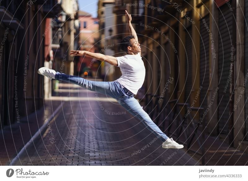 Black athletic man doing an acrobatic jump outdoors black street male cuban jumping young happiness person happy casual dancer lifestyle one adult acrobatics