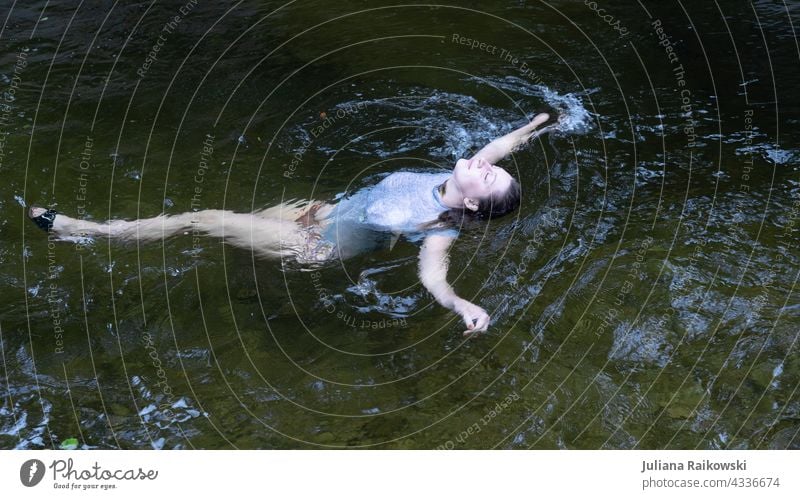 Woman lying relaxed in the water Water Float in the water Swimming & Bathing Lake Waves Exterior shot Nature Colour photo Pond Surface of water Subdued colour