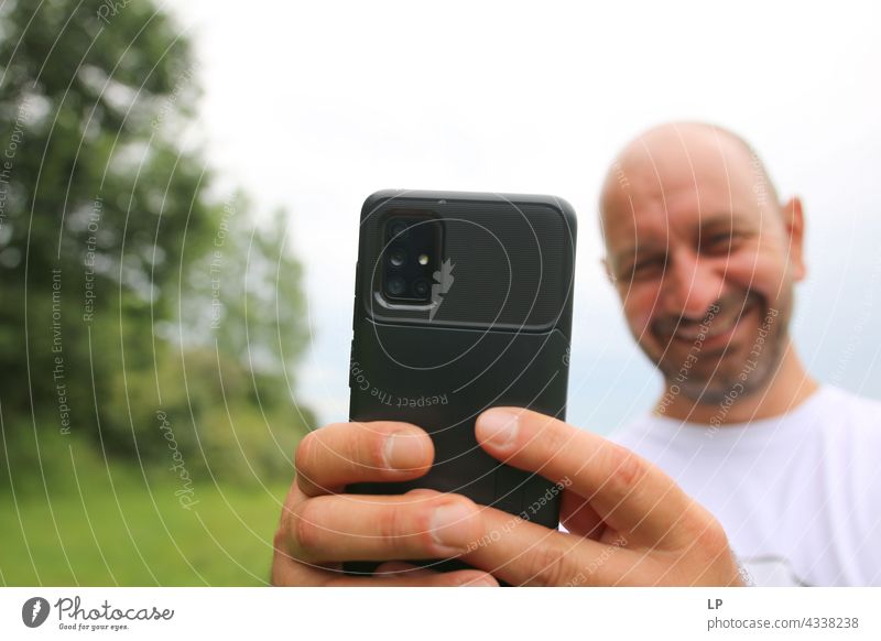 smiling man showing phone at the camera while taking a photo Emotions Tolerant Acceptance Peace solidarity Lovely multiethnic cooperation anti racism unity