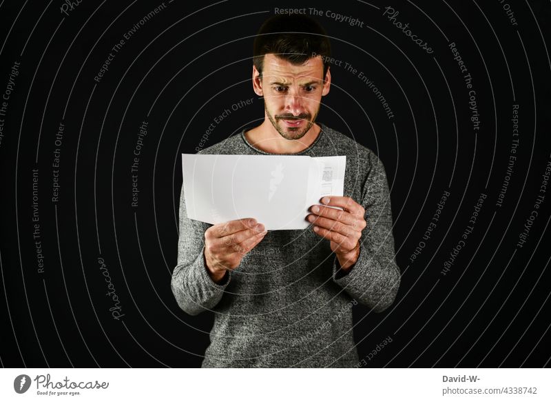 skeptical looking man opens an envelope Envelope (Mail) anxiously Man Looking Information message shocked Fear Communication