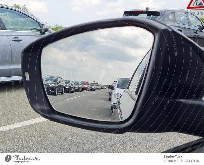 In the side mirror you can see a traffic jam with a rescue lane in front of a construction site rescue alley Construction site Traffic infrastructure Transport