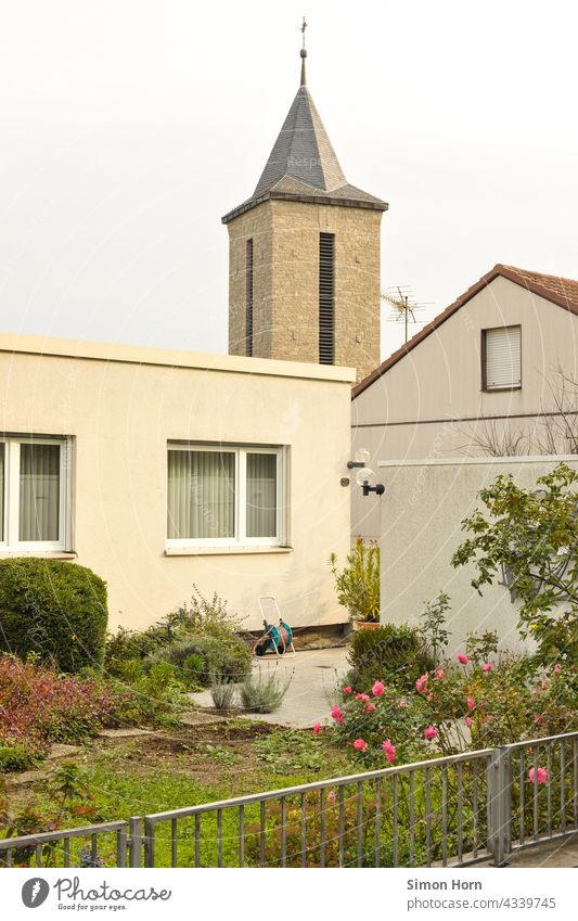 Church in the village Church spire Village Suburb bungalow House (Residential Structure) Front garden Crucifix Flat roof roses Garden fence rooftop landscape