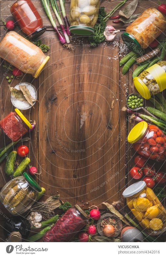 Various canned vegetables in jars on wooden background, top view. Frame. Seasonal homemade harvest preserving. various frame seasonal nobody natural traditional