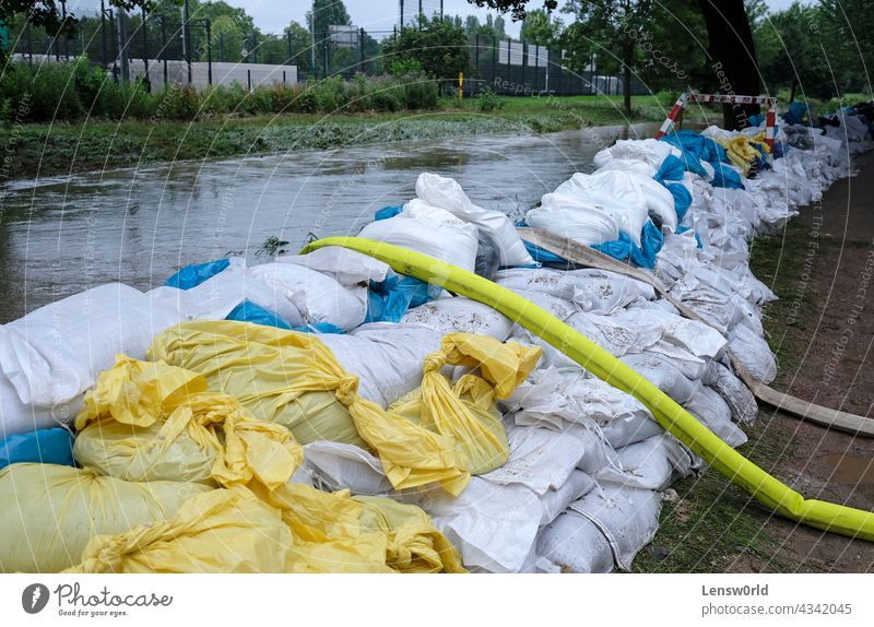Extreme weather - a line of sand bags and hoses to pump water out of flooded basements in Düsseldorf, Germany climate climate change disaster dusseldorf