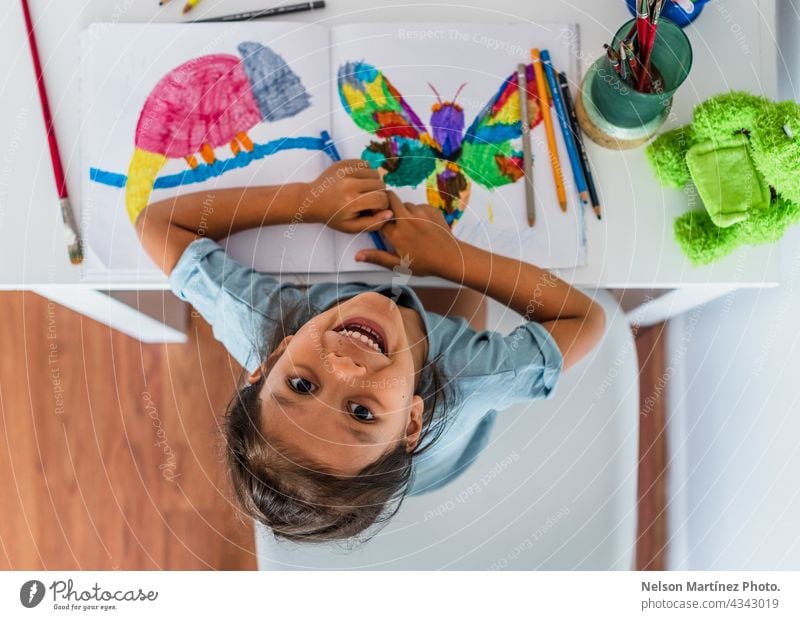Top view of a girl painting at home on the table happy playful female children young happiness person art paper inspiration little education kindergarten