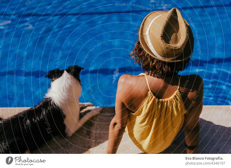 young caucasian woman sitting by pool side with cute border collie dog. Summer time, vacation and lifestyle swimming pool summer together love owner blue water