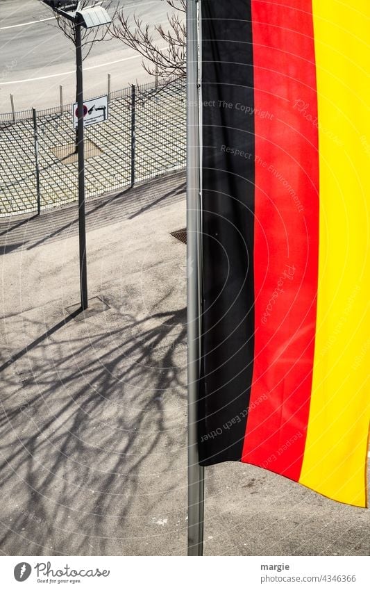 View from above on a vertical Germany flag Flag Blow Exterior shot Judder Deserted Flagpole Fence Street lighting Shadow Colour photo Beautiful weather