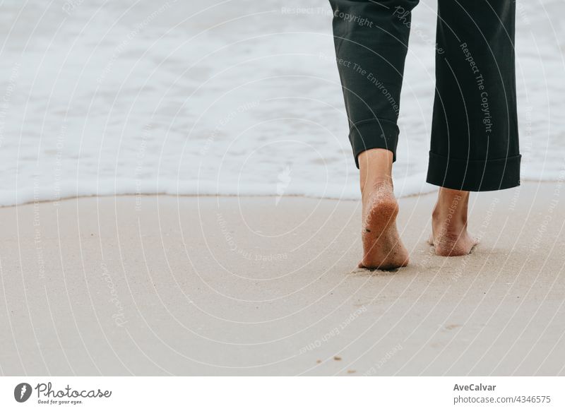 Close up of the back of a woman’s feet walking on the beach during a sunny day person step foot footprint relaxation health leg sand barefoot ocean space alone