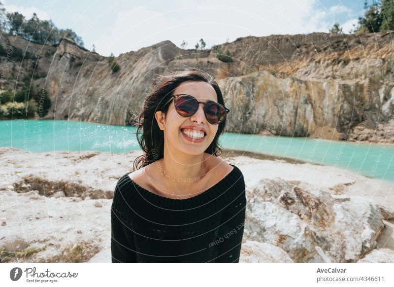 Young Moroccan woman with sunglasses on a tropical lake with crystal blue water, vacation and holiday concept lady smile person pretty enjoy model camera phone