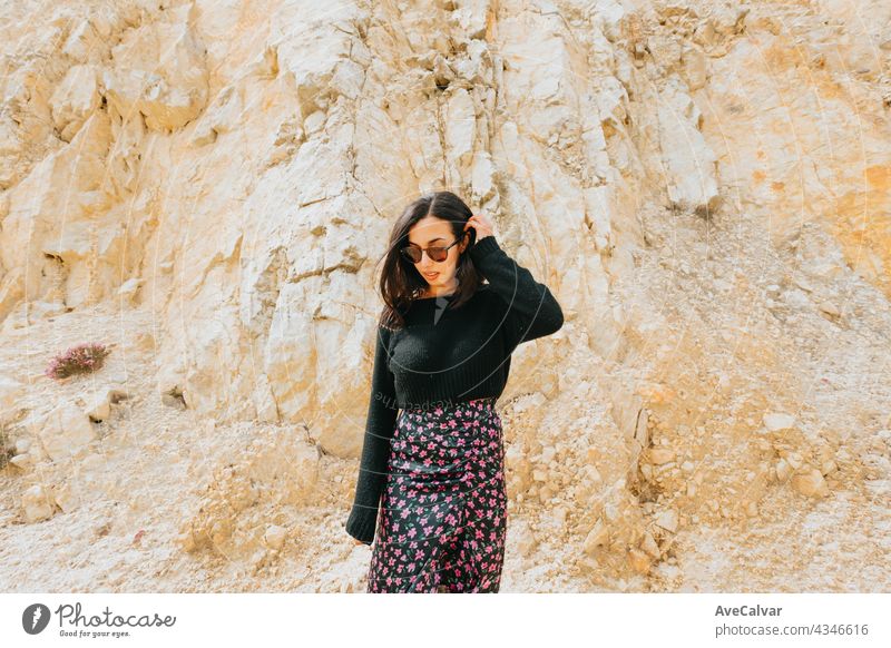 Portrait of a young woman with a pair of sunglasses in front of a marble giant rock, liberty and freedom concept lady smile person pretty enjoy model camera