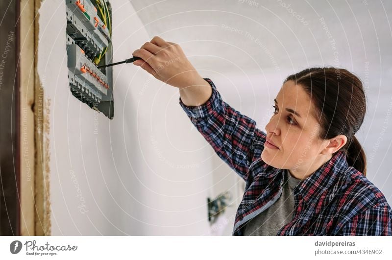 Electrician working on the distribution panel of a house woman electrical technician screwdriver electrician electrical installation inspection testing