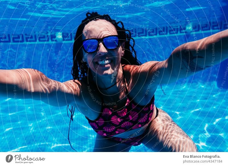 happy caucasian woman wearing sunglasses diving in swimming pool. underwater view. Summer time and vacation concept fun summer love blue water sunny day