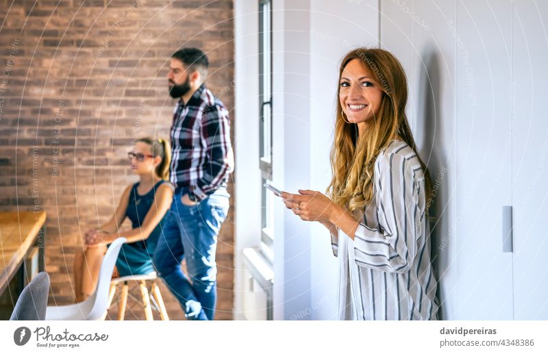Happy businesswoman looking at camera in office portrait happy looking camera coworking copy space colleague meeting standing tablet smiling coworker