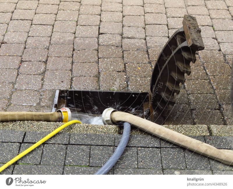 Flood damage Water Hose Drainage system Water hose pump out Water damage run off Gully manhole cover flipped up Street Sidewalk fire hose inundation Storm