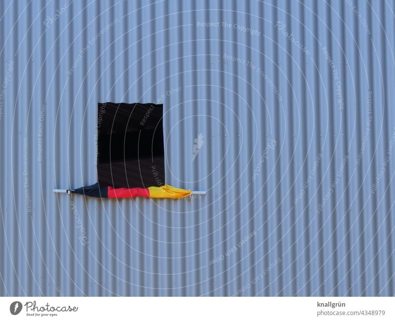 Unfurled Germany flag at an open window German flag Window coiled Aluminium facade Exterior shot Colour photo Deserted Architecture Patriotism German Flag Red