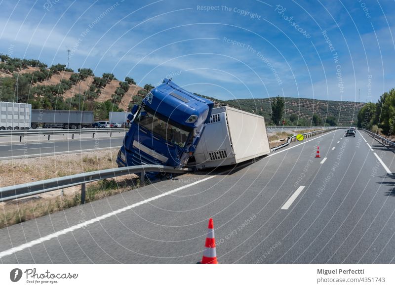 Truck with an accident refrigerated semi-trailer, overturned by the exit of the highway in the median of the highway. Camion Accidente Vuelco Frigorifico