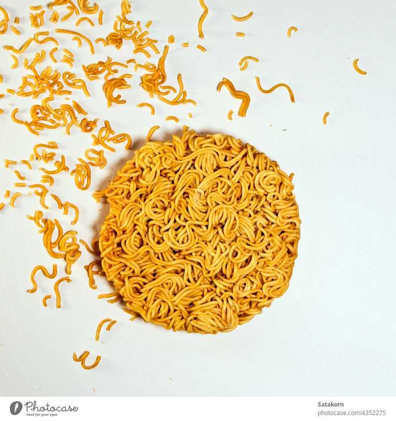 Instant noodle in the circle shape instant round fast food yellow meal cuisine dry lunch junk flour uncooked quick cheap salty unhealthy background white