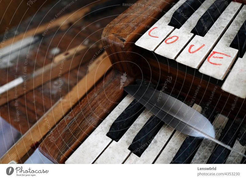 The word "Love" written on an old organ in an abandoned church antique background black closeup instrument key keyboard love melancholy music piano sentimental