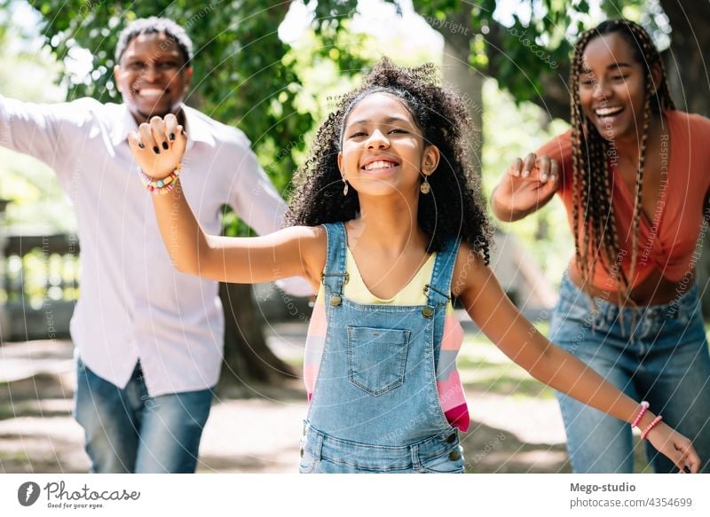 Family enjoying a day together at the park. family outdoors fun urban happy mother father daughter three love nature cheerful happiness african american black