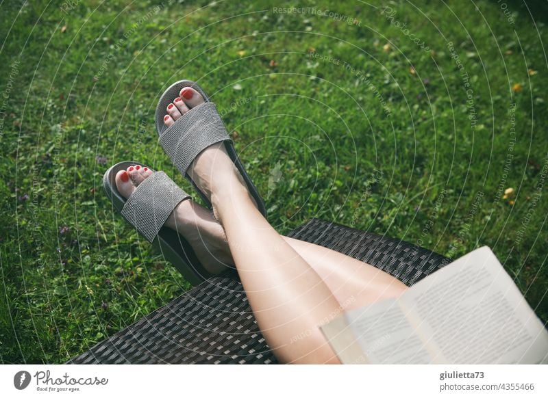 close up of female feet in glitter bath sandals, relaxing in garden, reading book Close-up Legs Woman feminine High heels Exterior shot Summer Garden Couch