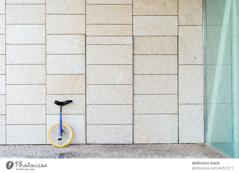 Unicycle parked near modern building unicycle urban wheel transport contemporary vehicle architecture geometry exterior construction structure stone shape glass