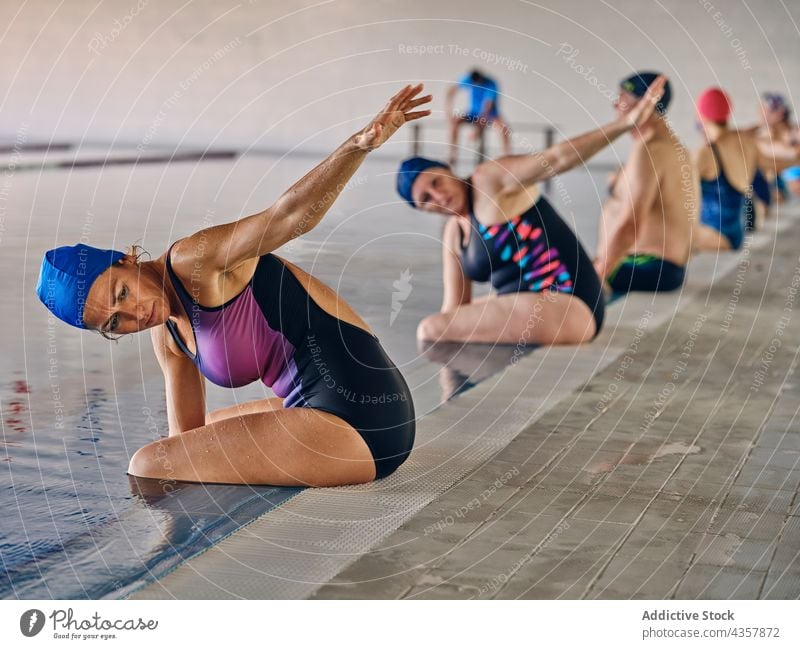 Company of people doing exercise during water aerobics company instructor trainer pool poolside training activity healthy practice sit workout body wellness