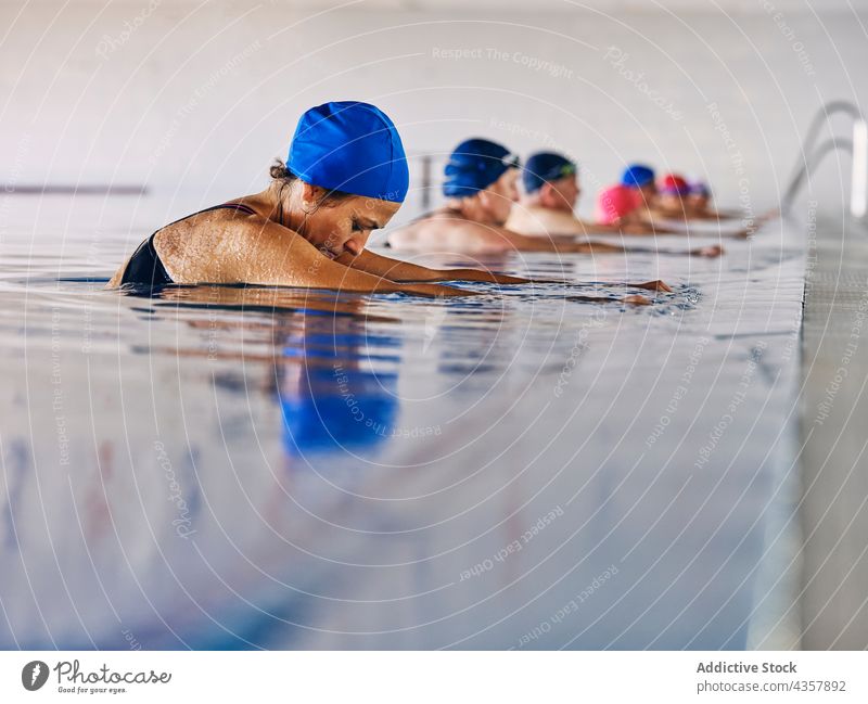 Company of people in swimming pool during water aerobics training company exercise group class aqua activity healthy practice workout body wellness vitality