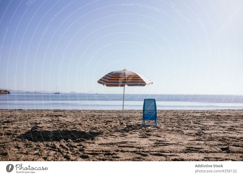 Summer umbrella and chair placed on sand beach summer vacation beach umbrella sea travel holiday water outdoors sky seaside freedom sunny coast vacations ocean
