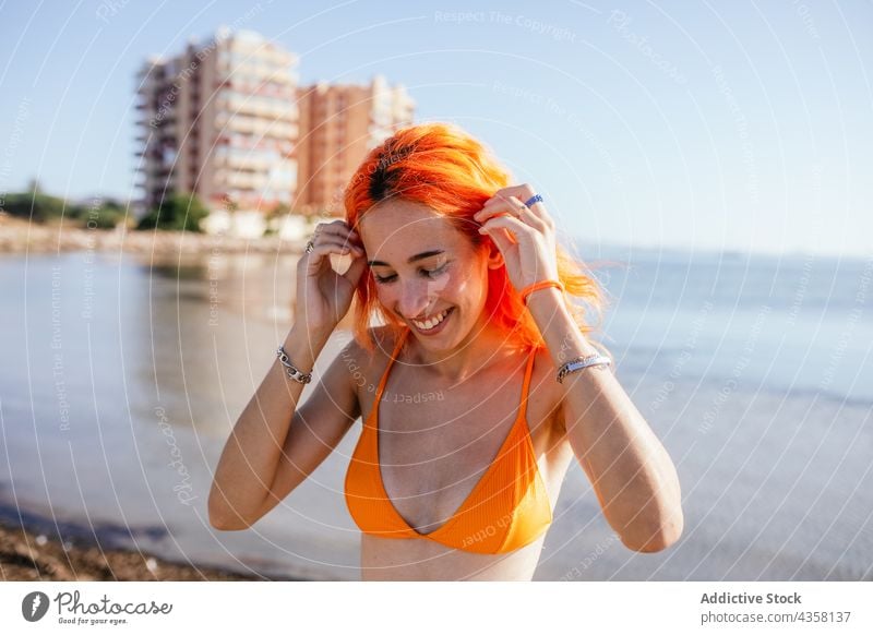 Young cheerful woman at beach bikini smile summer vacation sea travel holiday pale fit young redhead happy slim orange female water sand lifestyle people