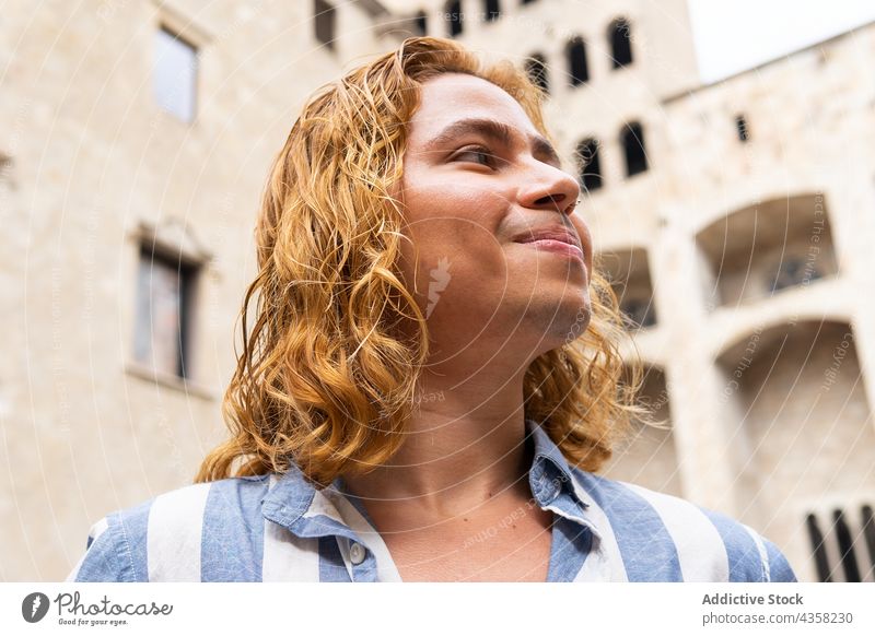 Carefree man with long hair in city carefree smile freedom enjoy peaceful street happy summer appearance male calm glad delight tranquil serene urban dreamy