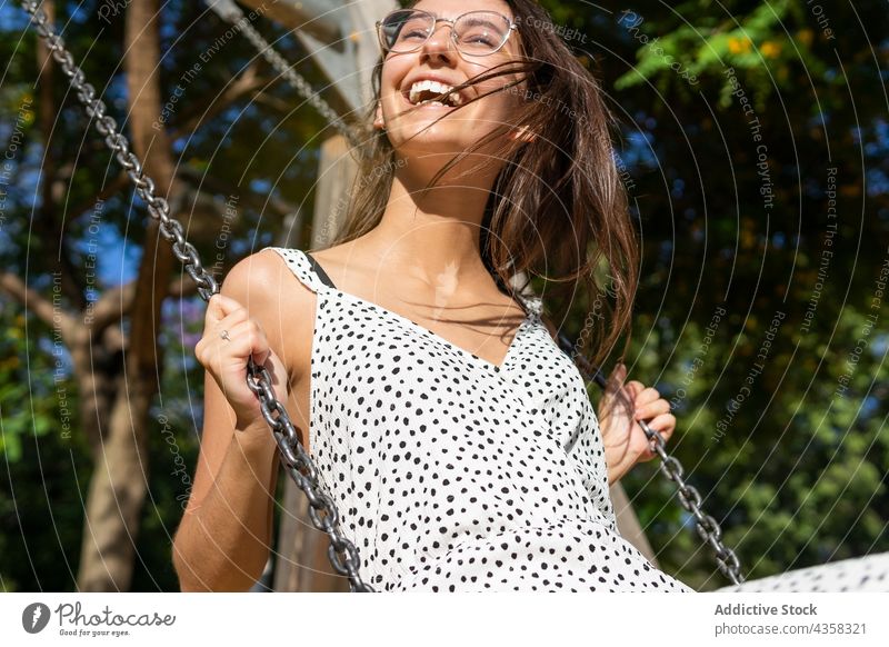Smiling young woman swinging fun park freedom summer play happy person female happiness girl leisure people adult beautiful lifestyle outdoor activity