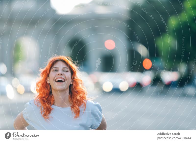 Happy redhead woman laughing in city ginger cheerful happy positive red hair eyes closed female street joy enjoy content excited urban style glad carefree