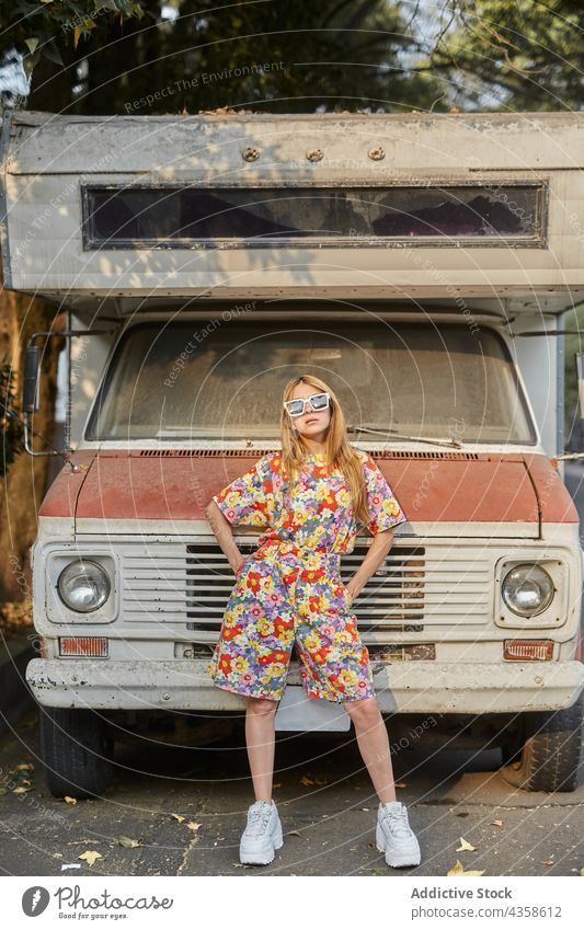 Stylish woman standing near abandoned car in city style overall old trendy summer confident female young fashion outfit serious shabby determine self assured